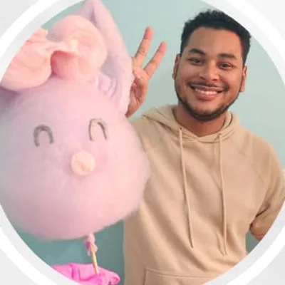 Aluno sorrindo com a escultura de coelhinha rosa que fez