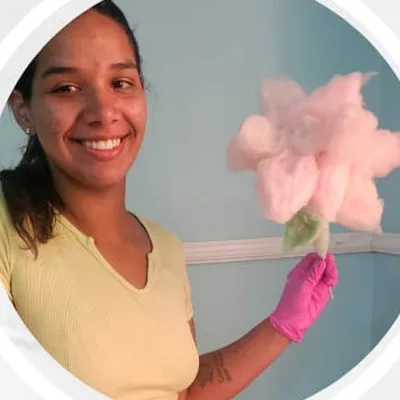 Aluna sorrindo com a escultura de flor que fez