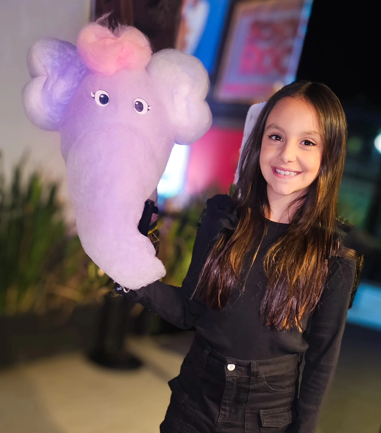 Adolescente sorrindo com um elefante lilás de algodão-doce