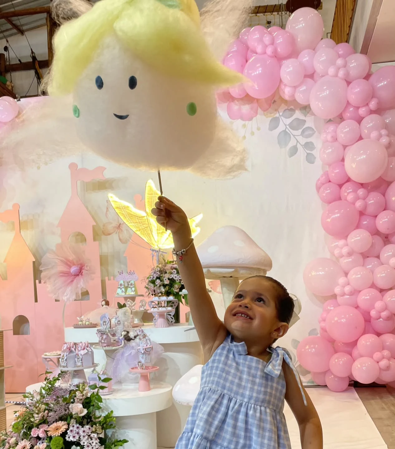 Menina estendendo a mão para tocar uma escultura de algodão-doce