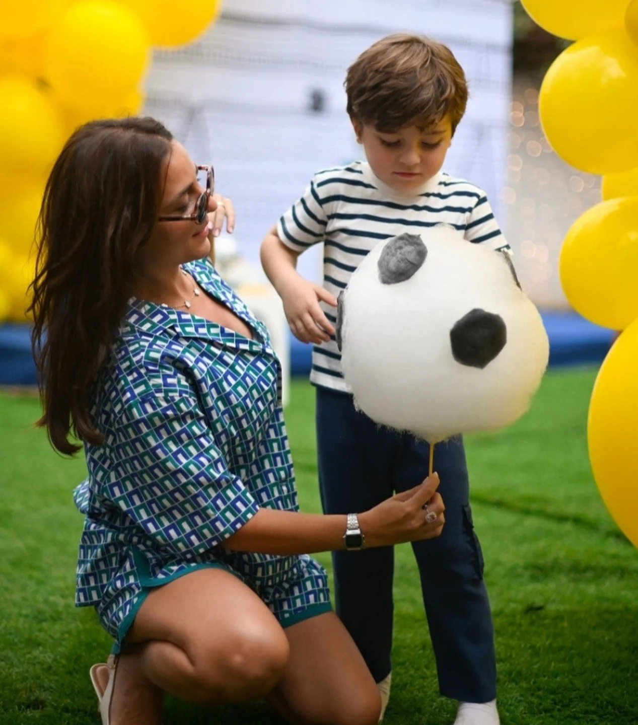 Mãe e filho com uma bola de futebol de algodão-doce