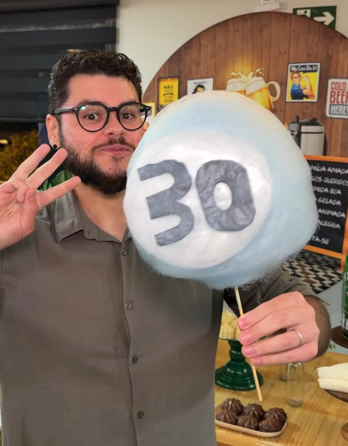 Aniversariante com uma escultura de algodão-doce com o número 30