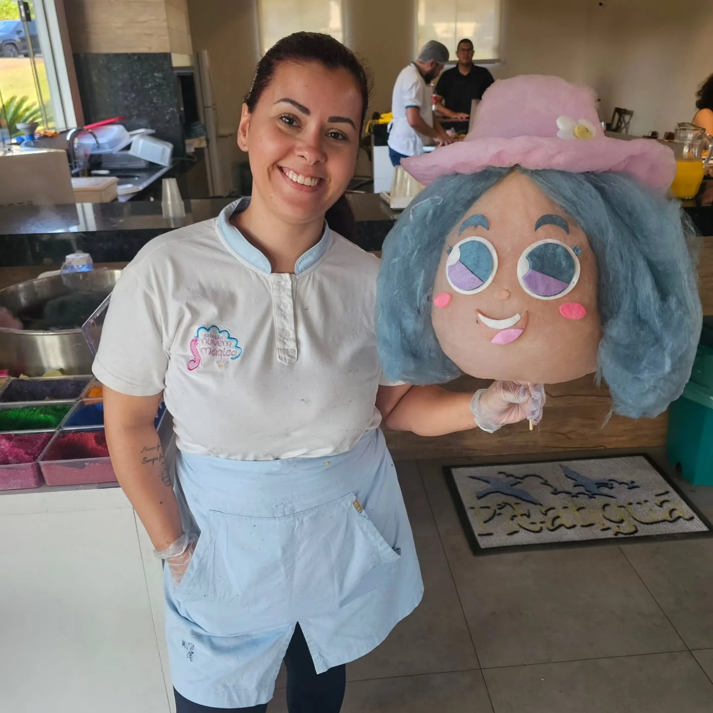 Artista com uma boneca de cabelo azul em algodão-doce