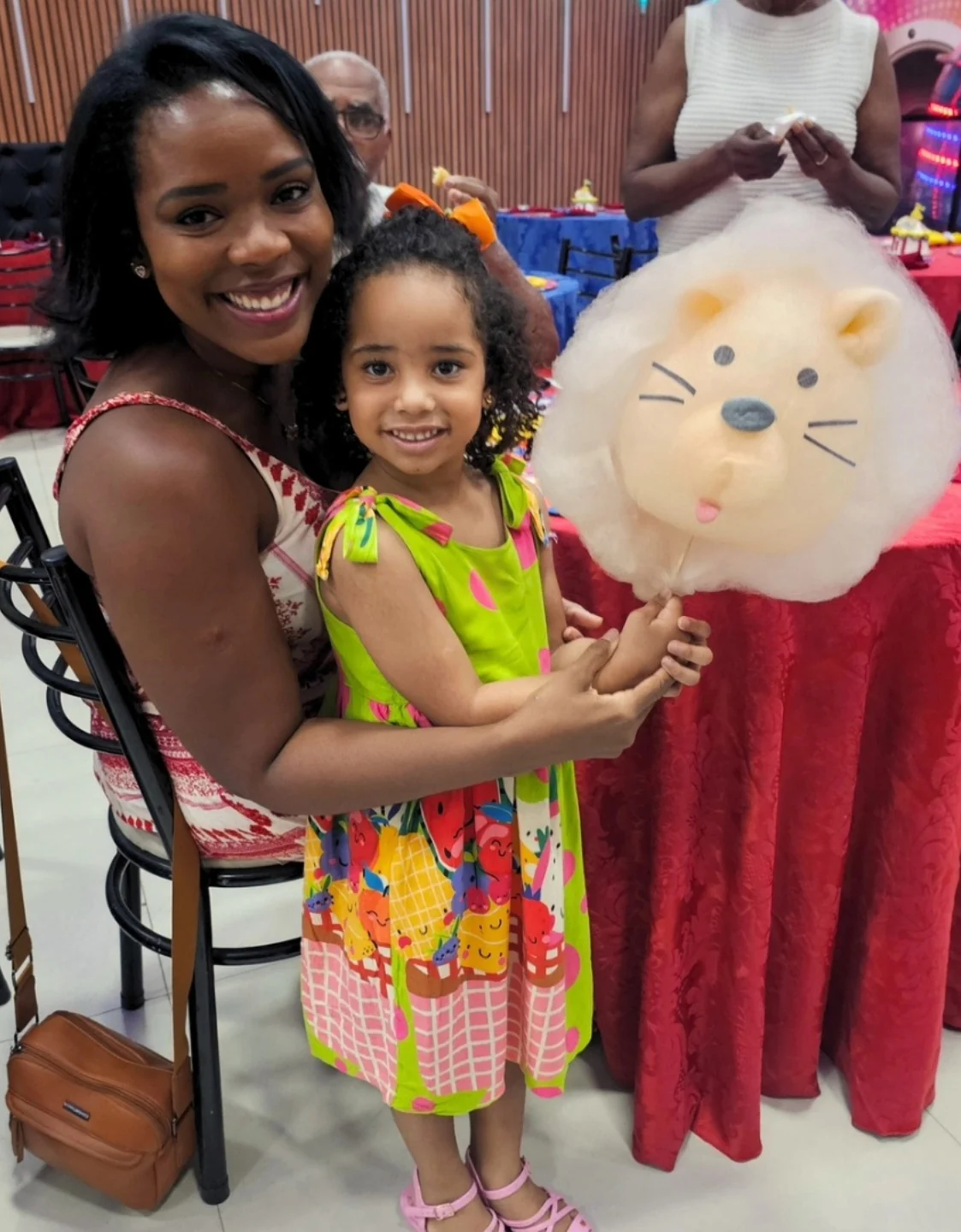 Mãe e filha com um gatinho de algodão-doce